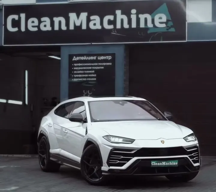 Вывеска CleanMachine над боксом, перед ней белый Lamborghini Urus